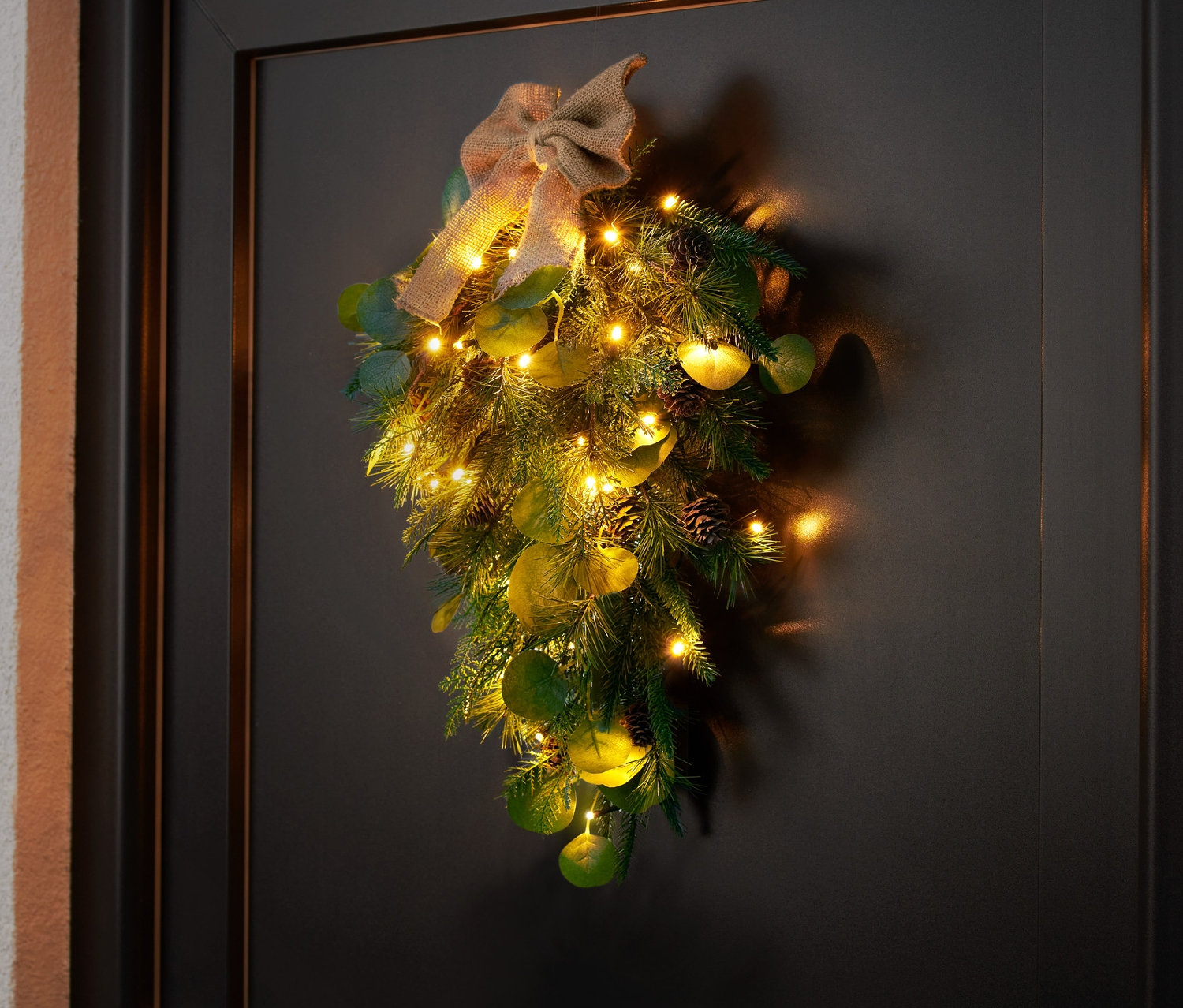 LED-Türdeko hängt an einer schwarzen Tür.