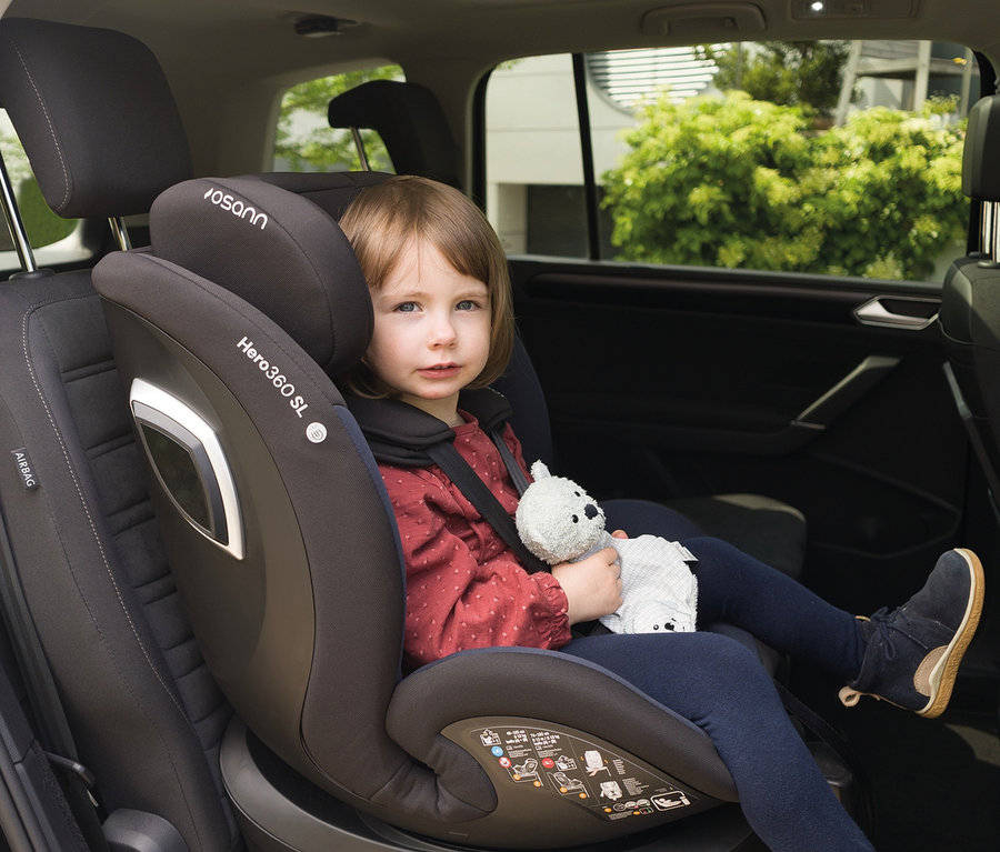 Ein Kind sitzt im Osann Kindersitz »Hero360 SL« und hält einen Teddybären.