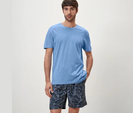 Mann trägt blaues Shorty-Pyjama-Set.