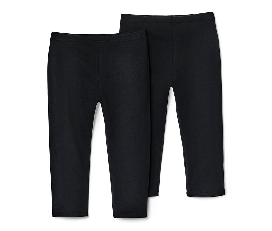 Zwei Kinder-3/4-Leggings in Schwarz liegen nebeneinander auf einem weißen Hintergrund.