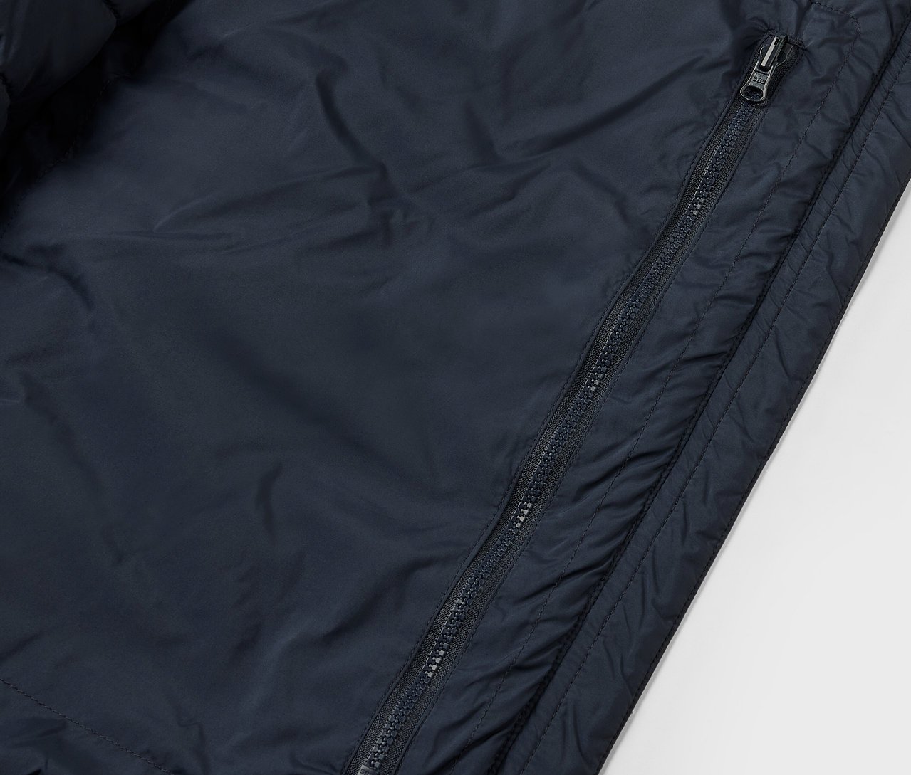 Detailansicht einer Steppjacke, packable, mit sichtbarem Reißverschluss.