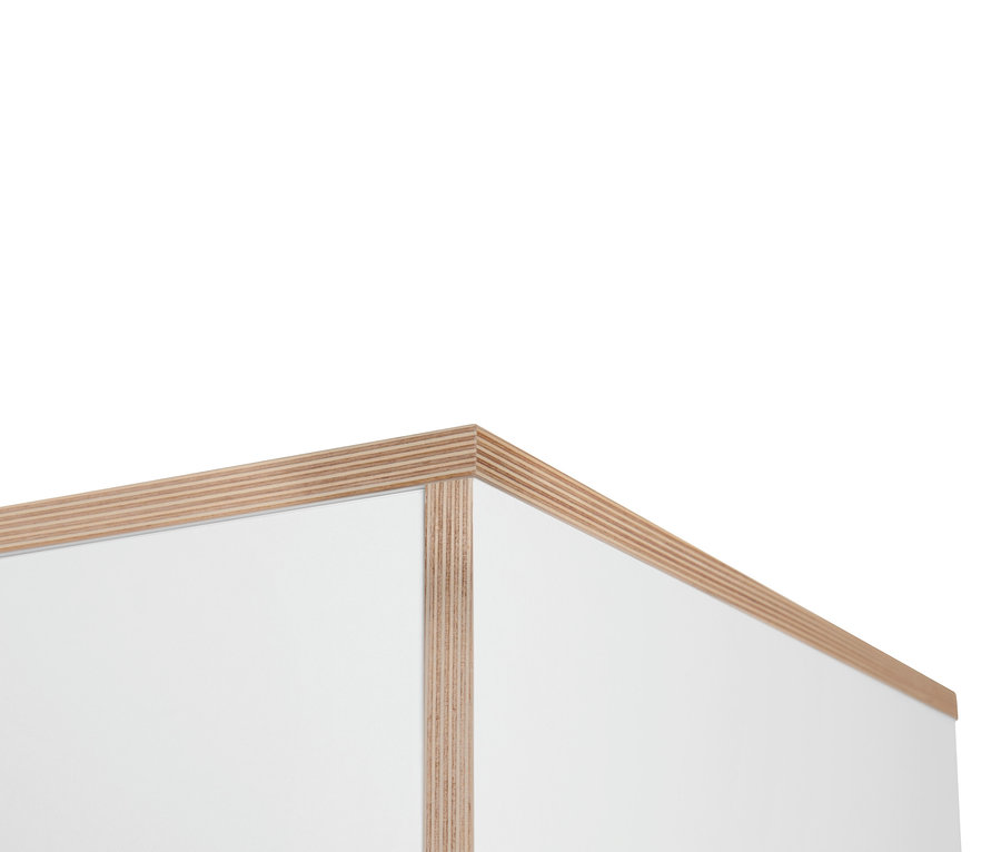 Detail einer Ecke eines weißen Schranks mit Furnierkanten.