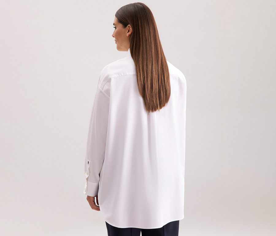 Frau von hinten, die eine weiße Seidensticker Oversize Longbluse trägt.