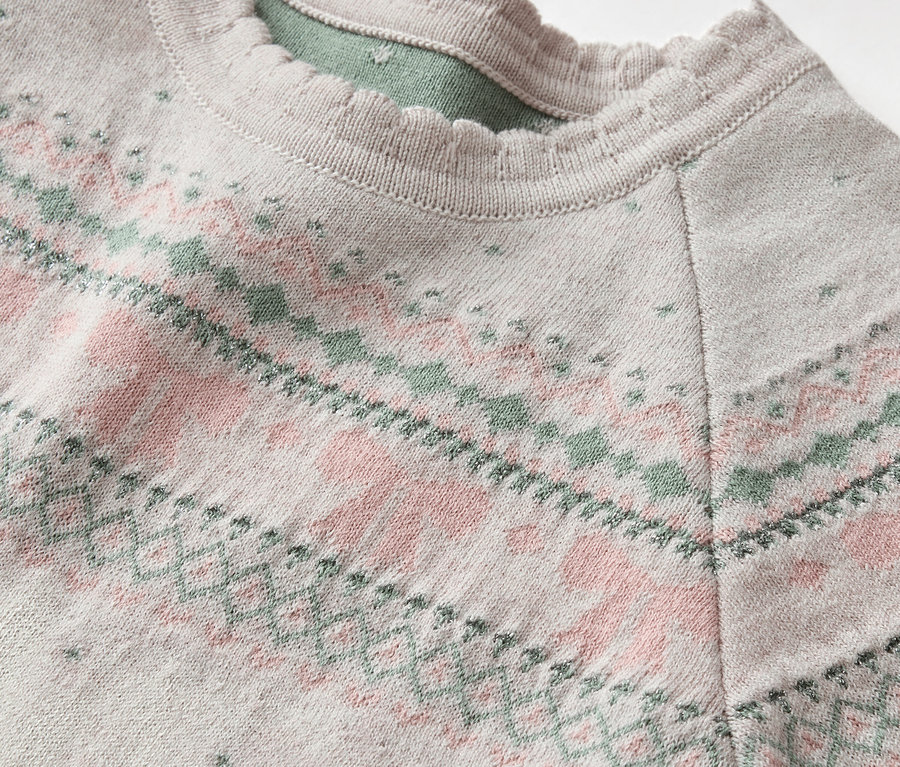 Detailansicht eines grauen Pullovers mit rosa-grünem Muster und Rüschenkragen.