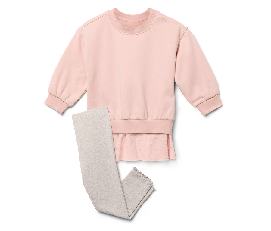Rosa Sweatshirt mit Rüschen und graue Leggings liegen auf weißem Grund.