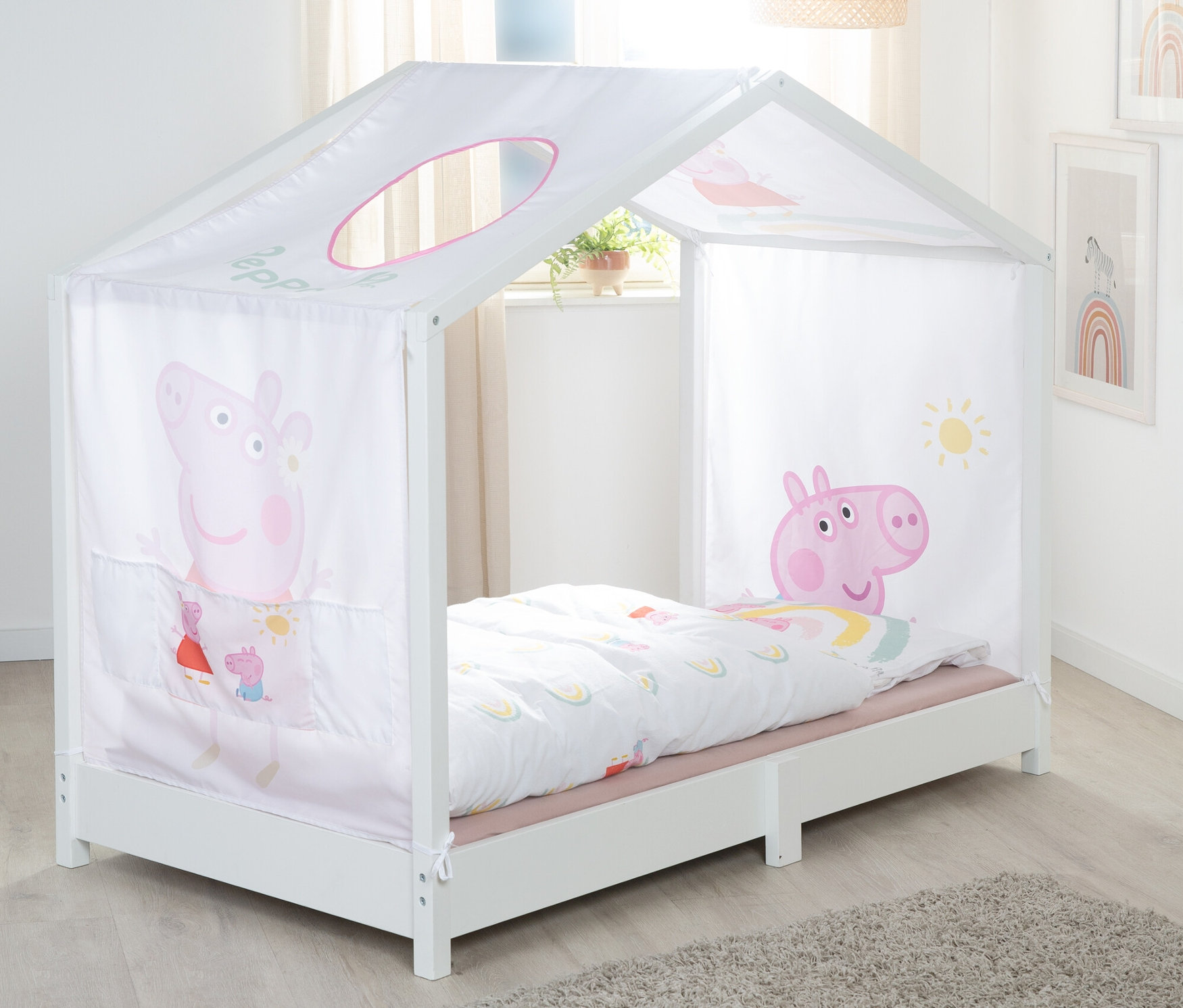 Weißes Kinderbett mit Peppa Pig Motiven und einem weißen Baldachin.