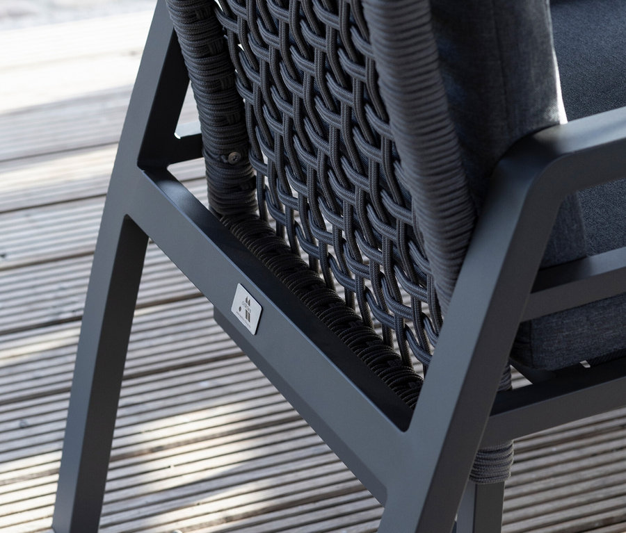 Detailansicht der Rückseite eines deVries Stuhls mit Seilgeflecht auf einer Holzterrasse.