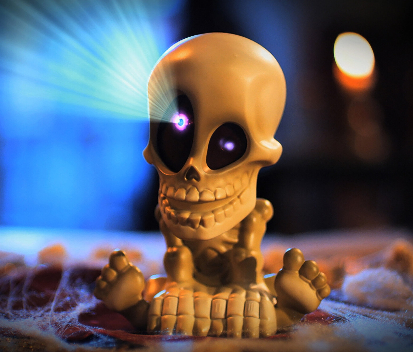 Gelbe Totenkopf-Figur aus dem Spiel "Geisterjagd" mit großen schwarzen Augen und weißem Schein aus den Augen.