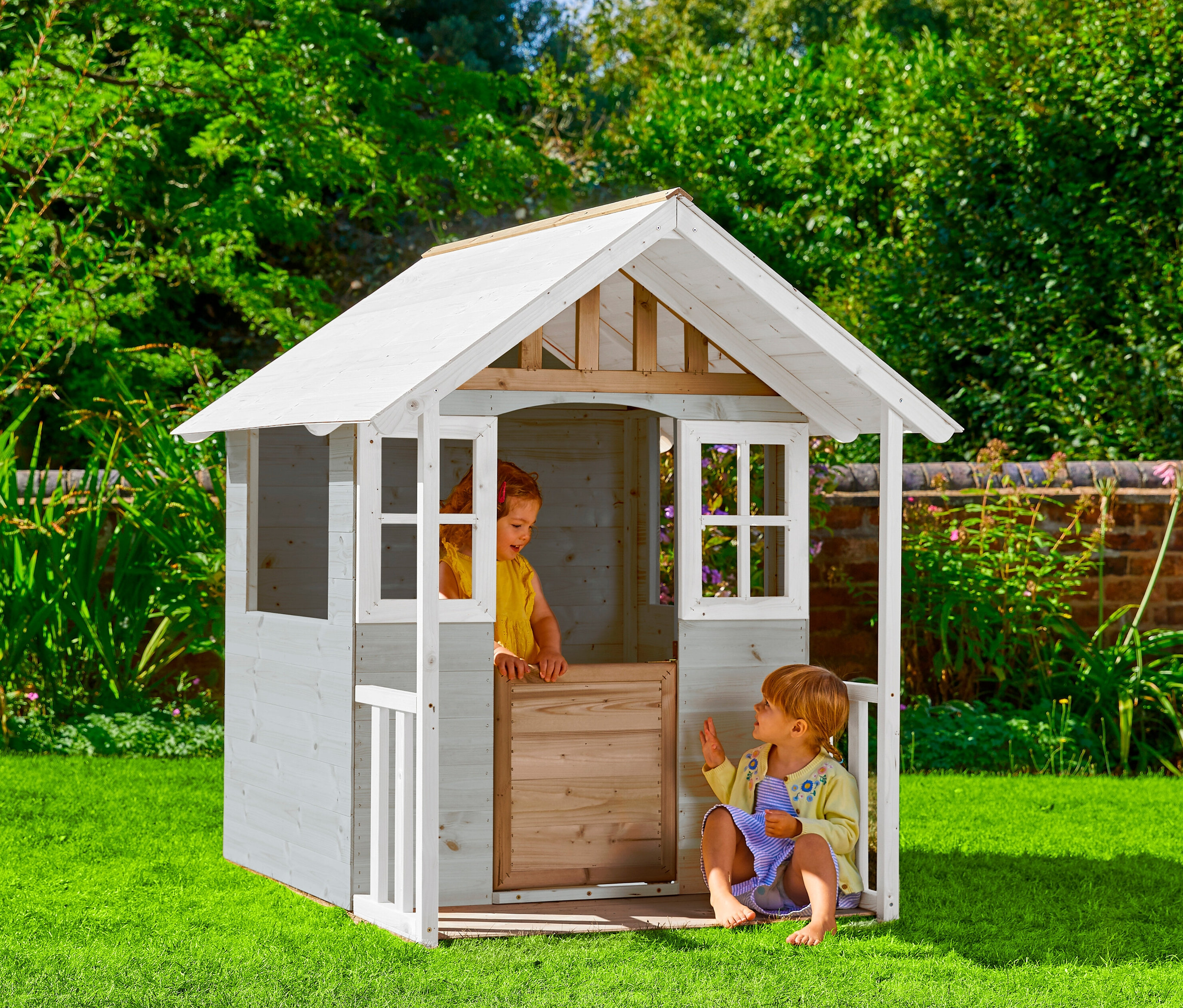 Zwei Kinder spielen draußen mit dem Spielhaus »Valli«.