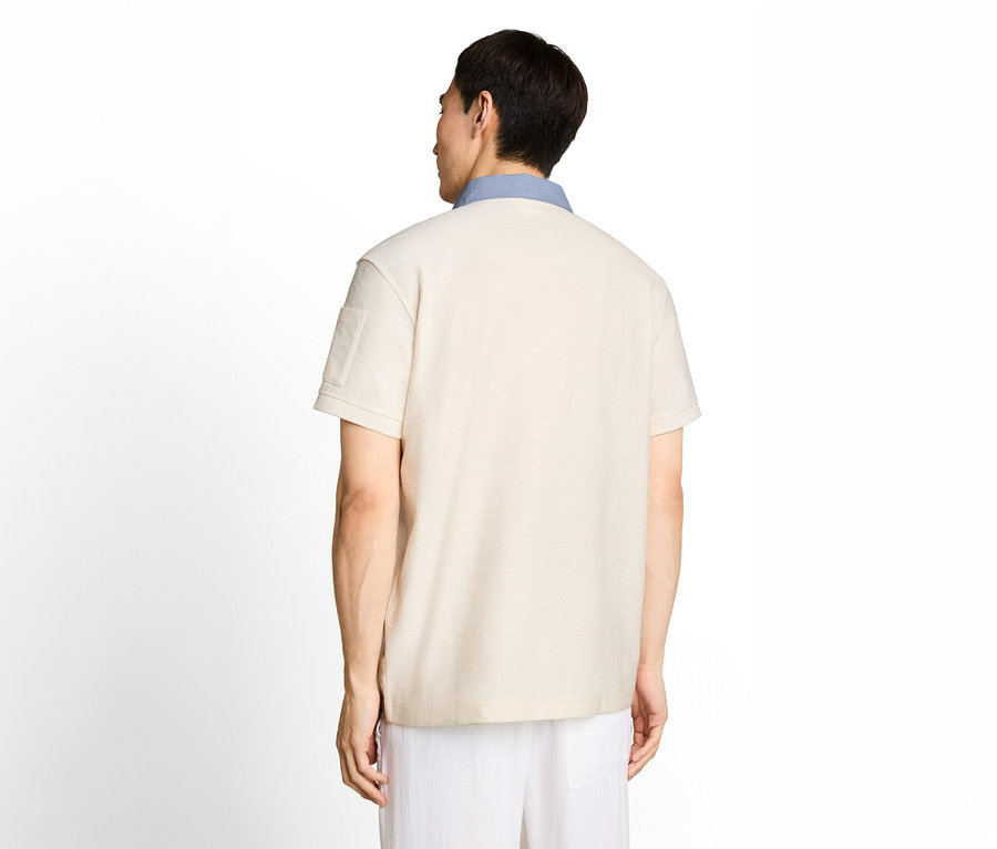 Mann von hinten, der ein beiges Kurzarm-Poloshirt mit hellblauem Kragen und weißen Hosen trägt.