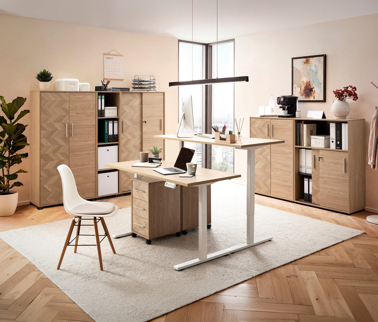 Büro mit höhenverstellbarem Schreibtisch, Laptop, PC, Büromaterial, Aktenschränken und Stuhl auf einem Teppich.