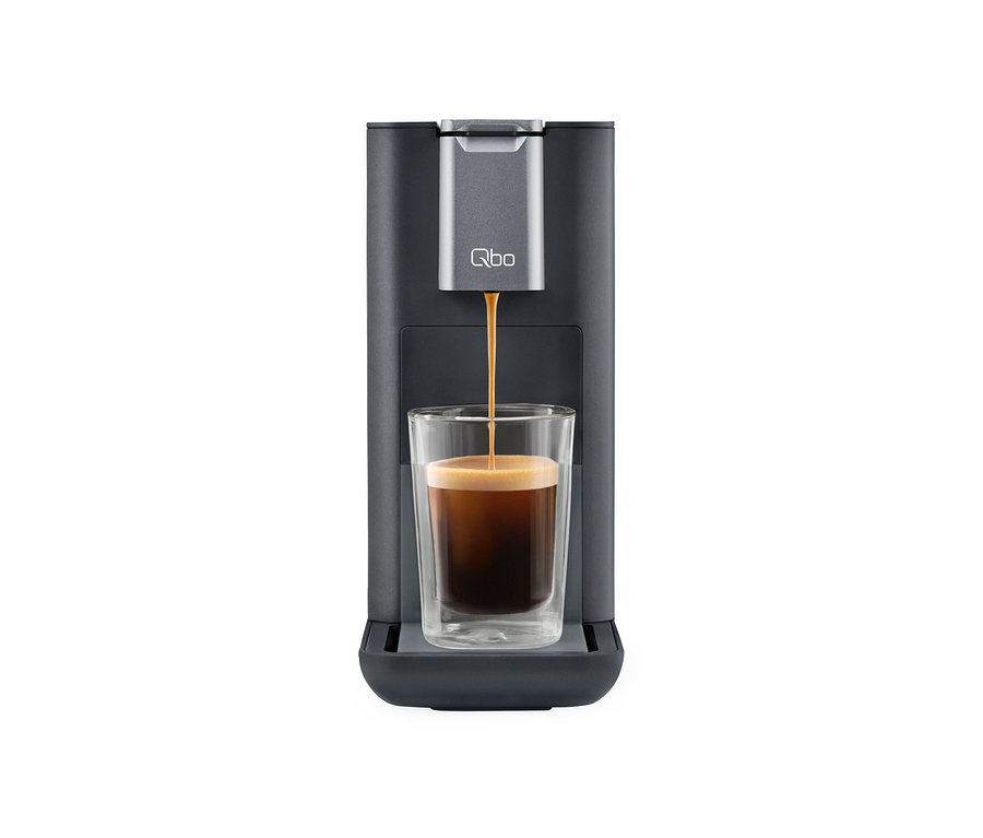 Kaffee läuft aus Qbo ESSENTIAL Dark Stone Kaffeemaschine in ein Glas.