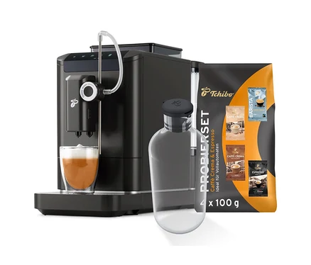 Ein schwarzer Kaffeevollautomat bereitet ein Getränk in einem Glas zu, daneben stehen eine Flasche und eine Kaffeepackung. Zu sehen ist das Esperto2 Milk Starter-Set.