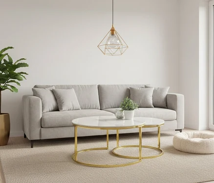 Ein modernes Wohnzimmer mit einem hellgrauen Sofa, zwei runden Beistelltischen mit weißer Marmorplatte und goldenen Gestellen, einer goldenen geometrischen Pendelleuchte, einer hohen Grünpflanze in einem goldenen Topf und einem flauschigen Haustierbett auf einem beigen Teppich.