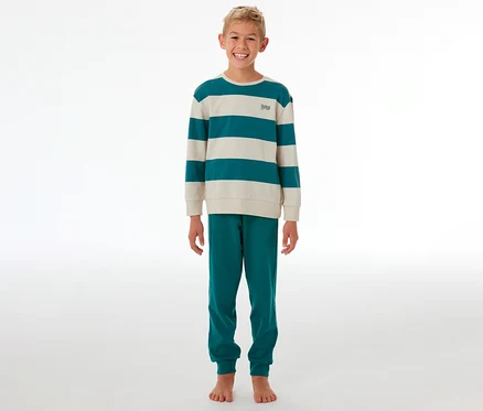 Lächelnder Junge steht in einem gestreiften SCHIESSER Kinder-Interlock-Pyjama in Türkis und Beige.