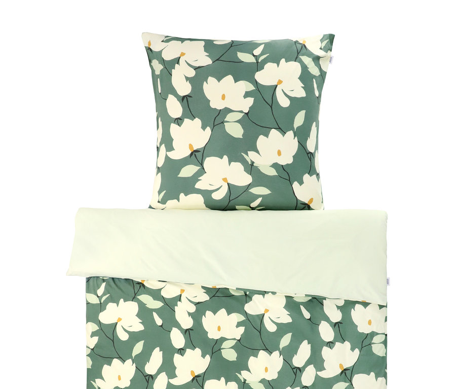 Jersey-Bettwäsche-Set mit dunkelgrünem Hintergrund und weißem Magnolienmuster, hellgrünen Blättern und gelben Blütenmitten.