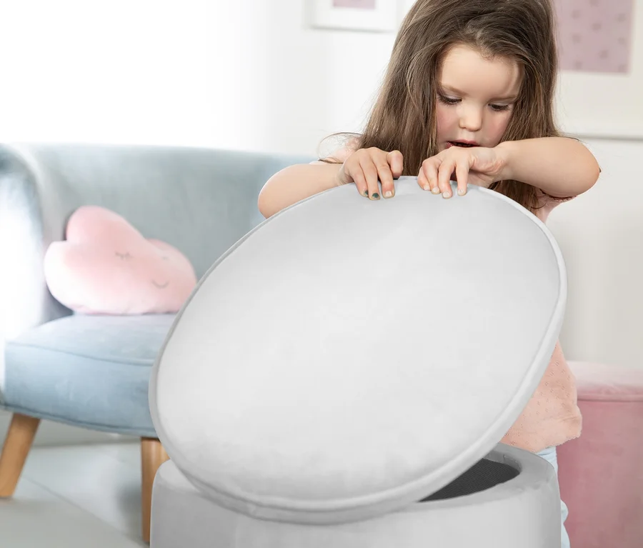 Mädchen öffnet grauen roba Kinderhocker Lil Sofa mit Aufbewahrungsfunktion.