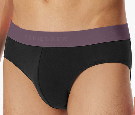 Torso eines Mannes, der schwarze SCHIESSER Slips mit lila Bund trägt.