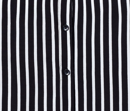 Detailansicht einer schwarz-weiss gestreiften Bluse mit Knöpfen.