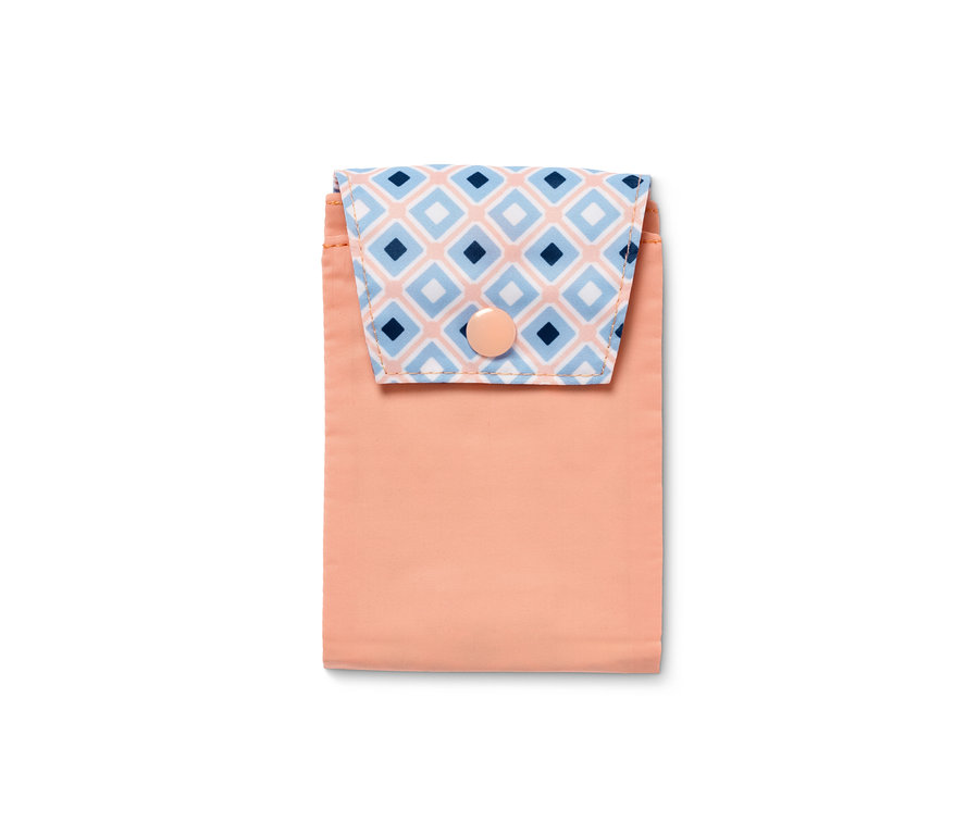 Eine Hygiene-Tasche mit einem pfirsichfarbenen Unterteil und einer Klappe mit blau-weißen Rauten.