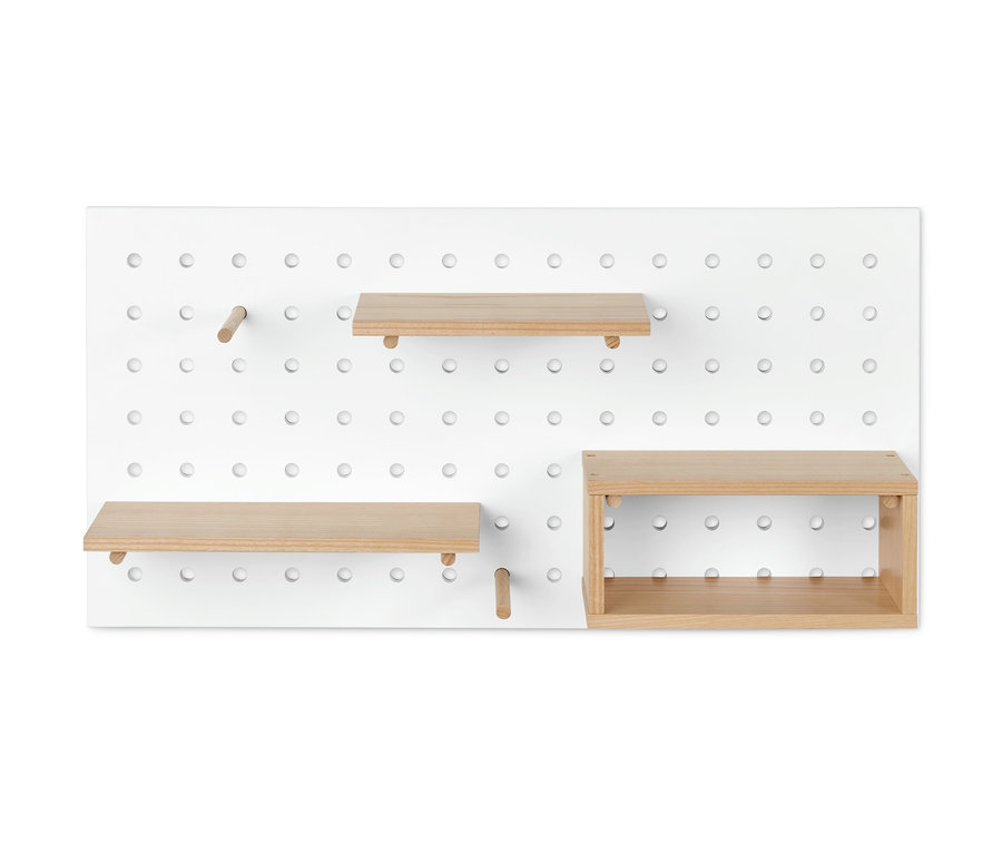 Eine weiße Lochplatte mit unterschiedlich platzierten Holzregalen.