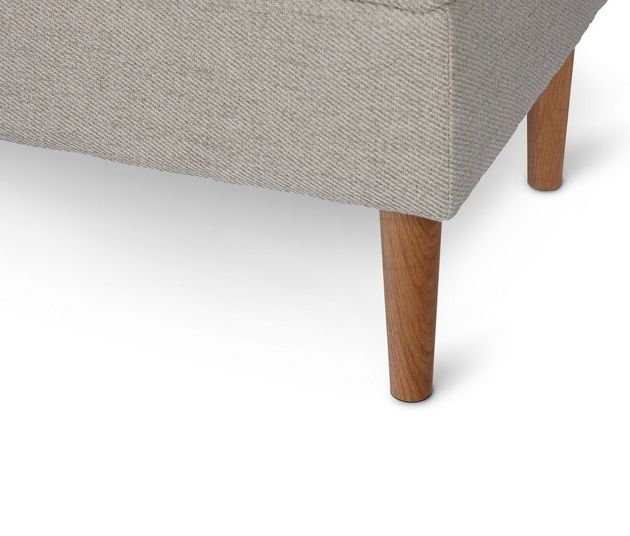 Detail einer Polsterbank mit Truhenfunktion und Holzfüßen.