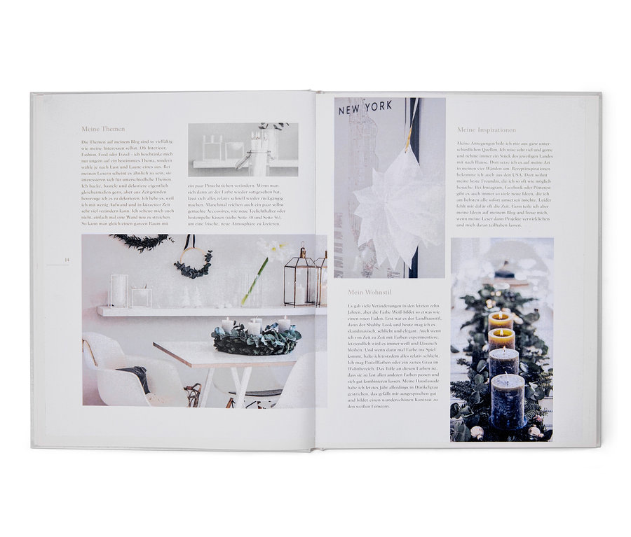 Offenes Buch zeigt links einen Tisch und Stuhl, rechts Kerzen und Grün. Buch »Weihnachtszauber«