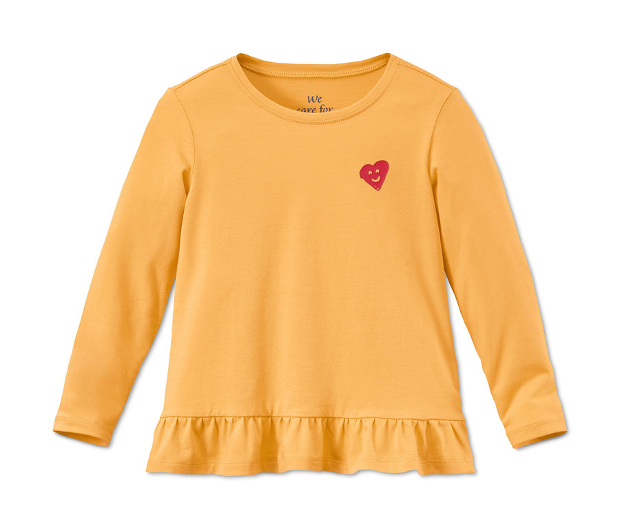 Ein gelbes Langarmshirt aus Bio-Baumwolle mit einem roten Herz und Rüschen.