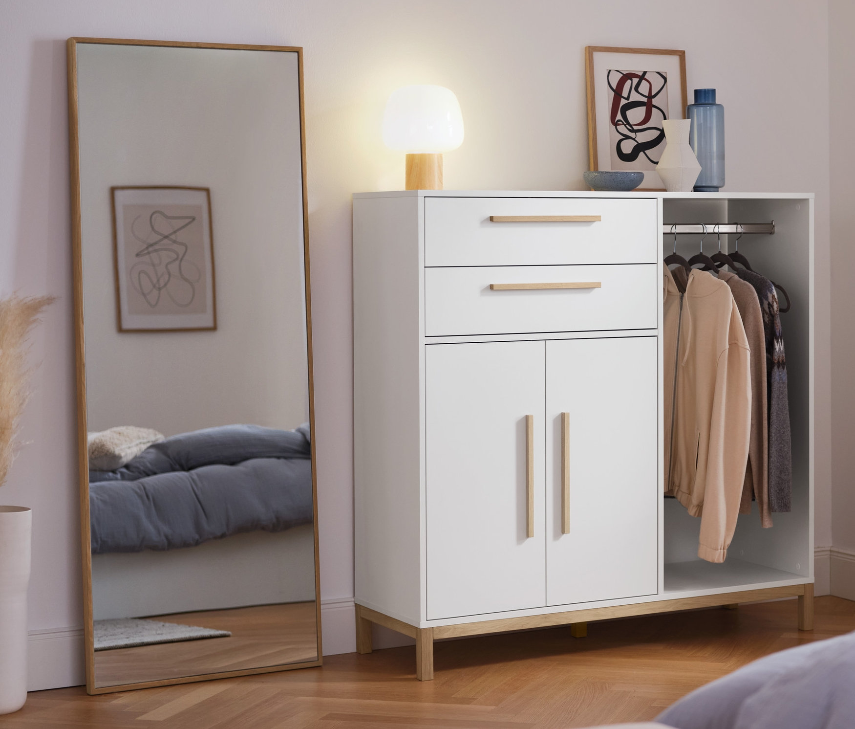 Im Schlafzimmer stehen eine Kommode »Eklund« mit Ankleide, ein Wandspiegel und eine LED-Akku-Tischleuchte.