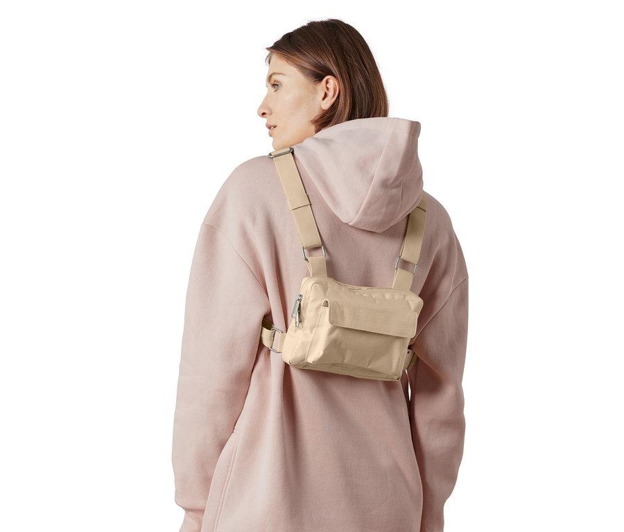 Frau trägt eine variable Umhängetasche und einen rosa Hoodie und eine Jogginghose.