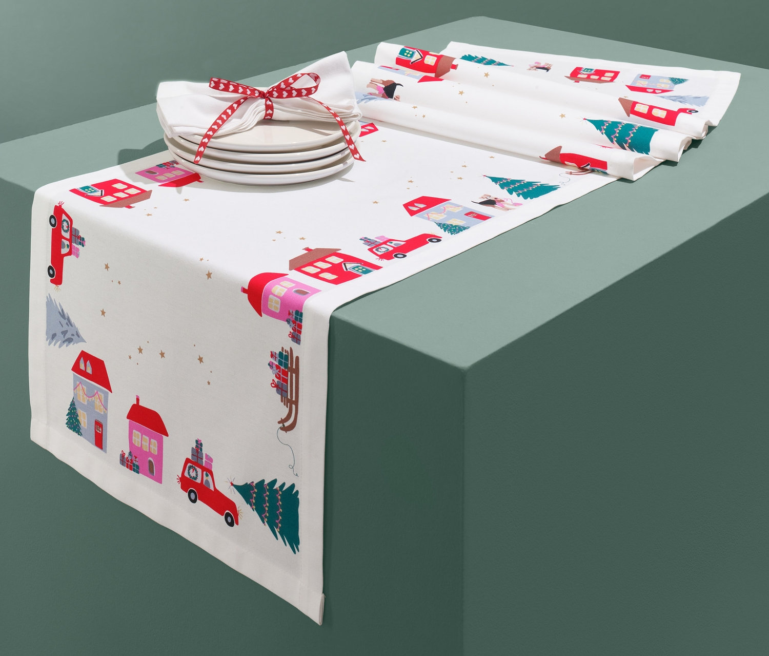 Tischläufer mit Weihnachtsmotiv von Häusern und Autos.