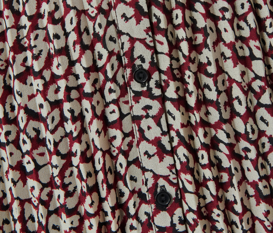 Detailansicht eines gemusterten Maxi-Kleids mit Knöpfen.