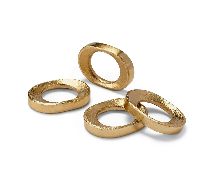 Vier goldene Serviettenringe auf einem weißen Hintergrund.