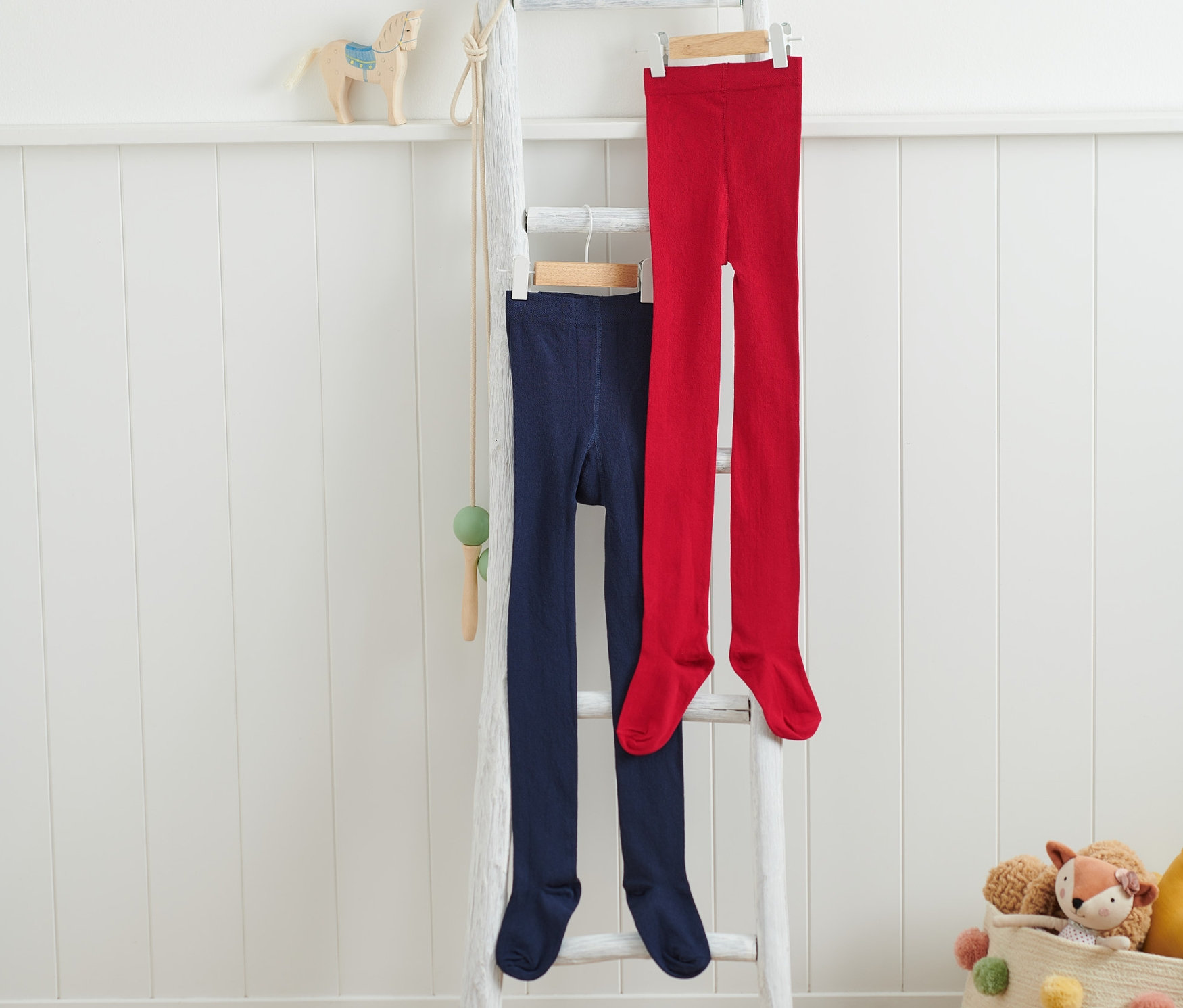 Zwei Kinder-Strumpfhosen hängen auf einer Leiter.