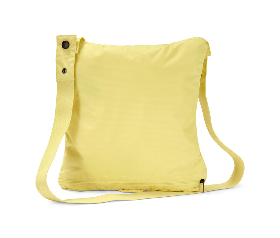 Gelbe Lightweight-Regenjacke »pack me« gefaltet in einer Tasche mit Riemen.