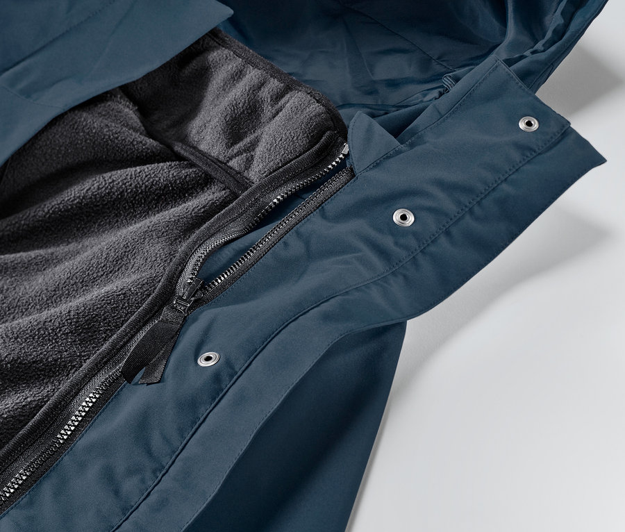 Detailaufnahme einer geöffneten, dunkelblauen 3-in-1-Regenjacke mit freiliegendem Fleecefutter.