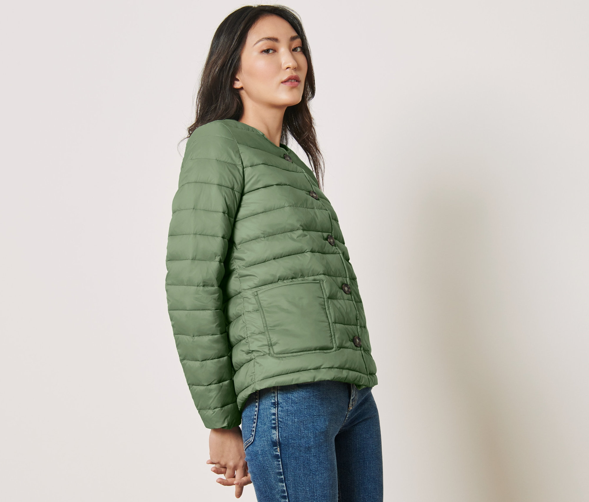 Frau posiert in grüner Steppjacke.