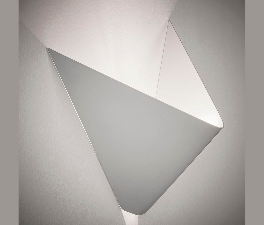 Weiße Wandleuchte in Form einer geometrischen Figur an der Wand befestigt.