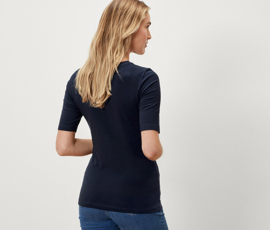 Frau trägt ein dunkelblaues Halbarmshirt.