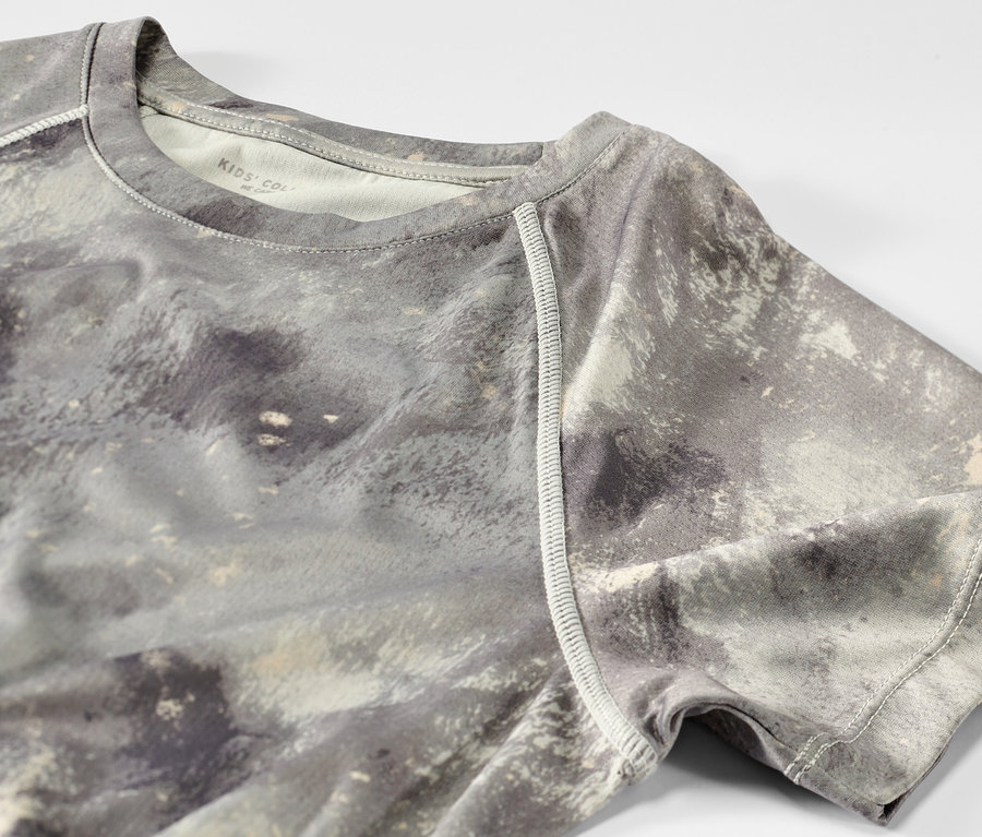 Detailansicht eines grünen Kinder-Sportshirts mit Alloverprint aus einem 2er-Set.