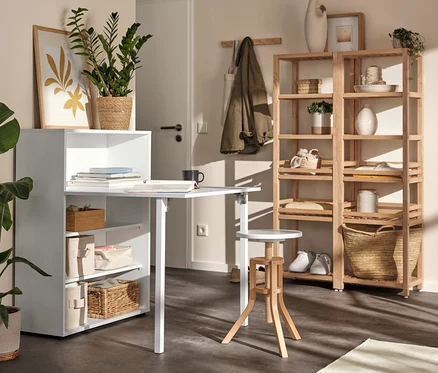 Weißes Regal mit ausklappbarem Tisch, Massivholzregal und Spindelhocker in einem Raum.