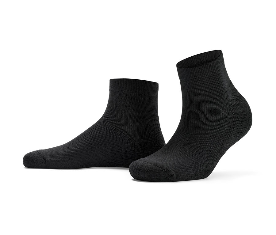 Zwei Paar kurze Sportsocken liegen auf dem Boden.
