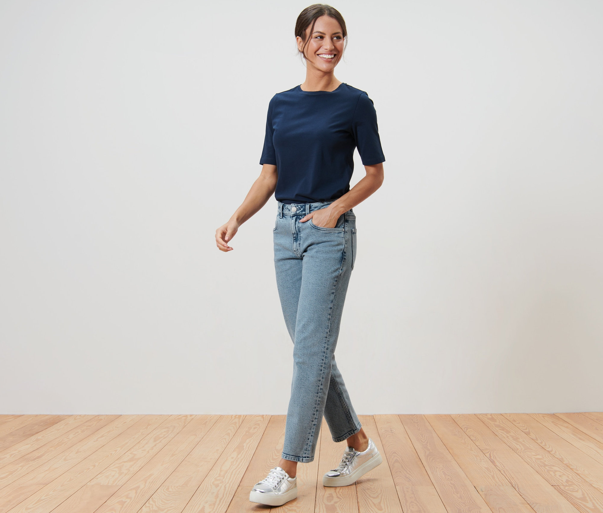 Frau geht mit Händen in den Taschen ihrer Modern Jeans – Fit »Ava«.