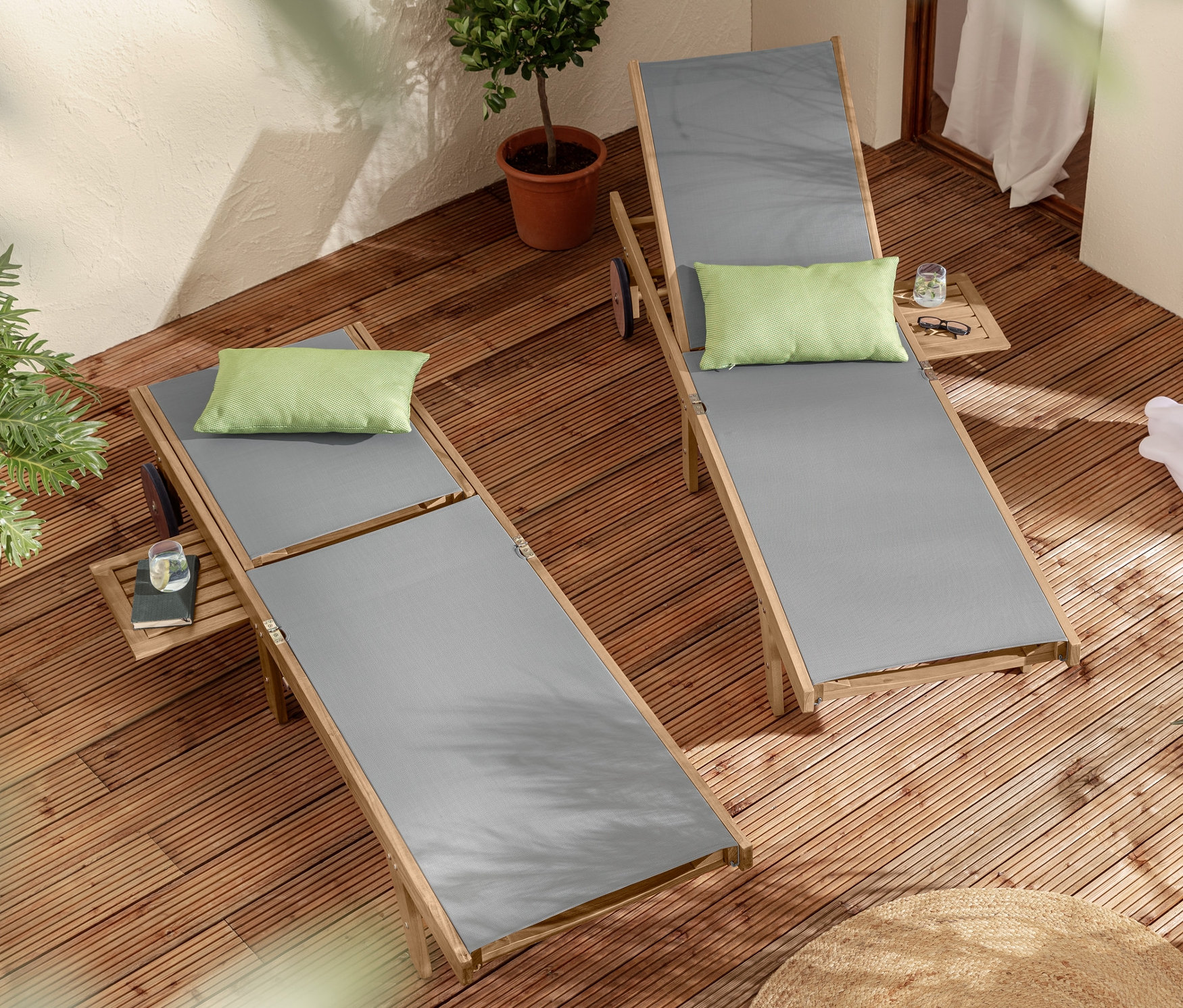 Zwei Liegen »Lenja« mit ausziehbarem Tabletttisch, Solar-Leuchte Frosch und 2 Outdoor-Kissen auf einer Holzterrasse.