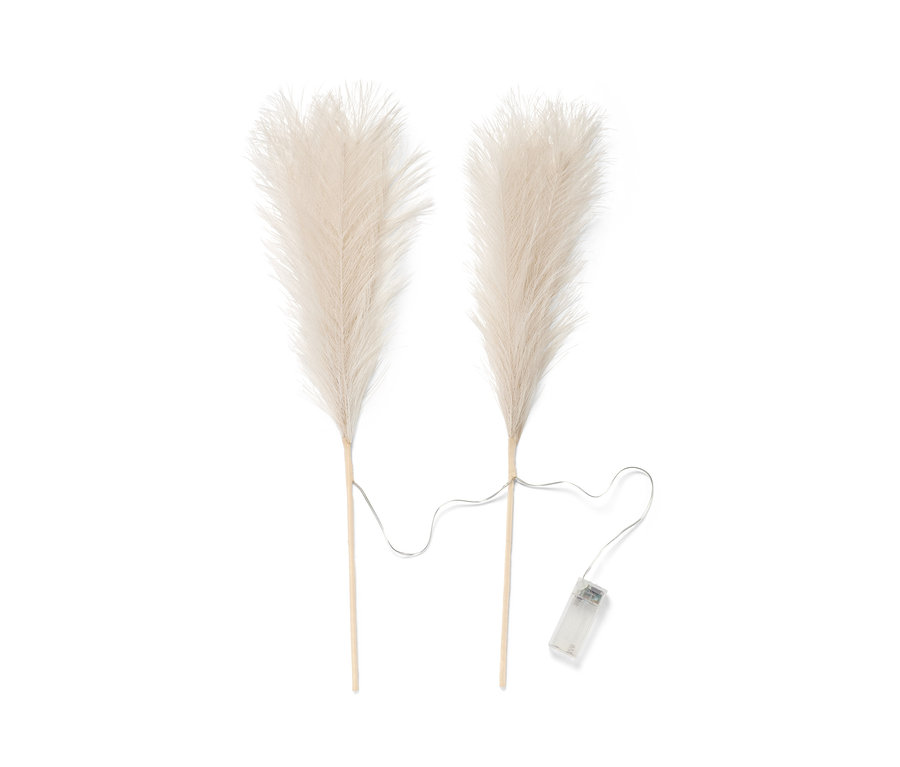 Zwei LED-Dekozweige »Pampasgras« liegen auf einem weißen Hintergrund.
