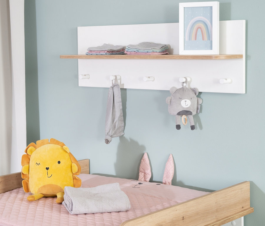 Gelbes Löwenkuscheltier sitzt auf rosa Decke mit Hasenohren. An der Wand hängt roba Wandgardarobe »Ava«.