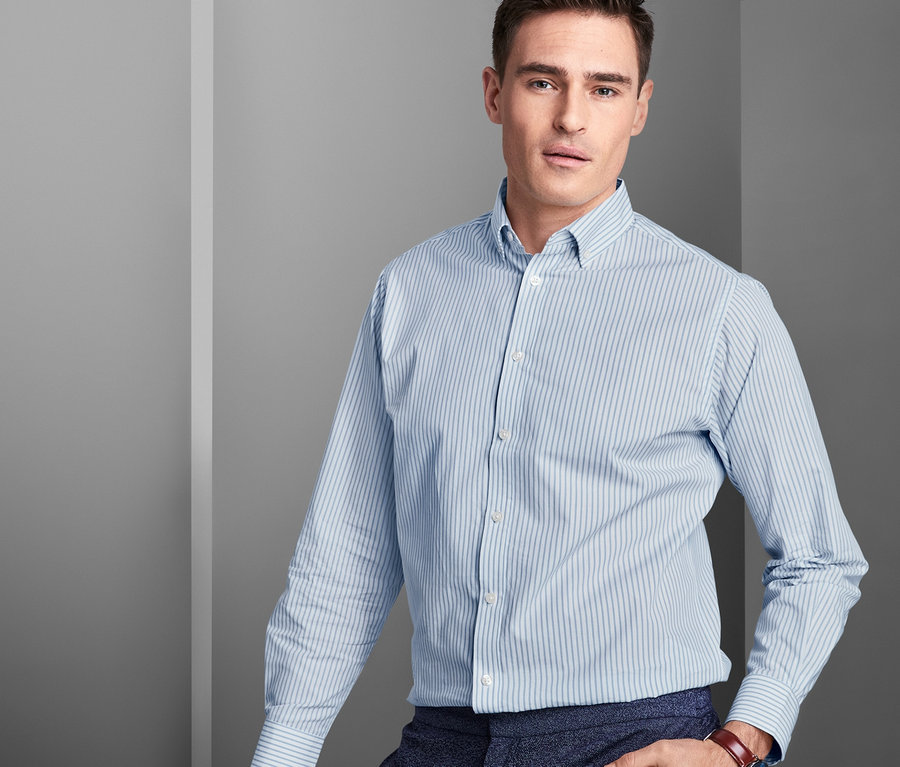 Mann posiert in einem Hemd mit Button-down-Kragen, Comfort Fit, und einer dunkelblauen Hose.