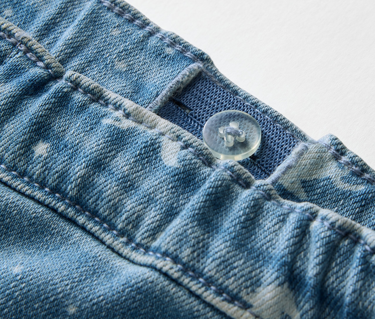 Detailaufnahme von Kinder-Treggings mit Knopf und verstellbarem Gummibund.