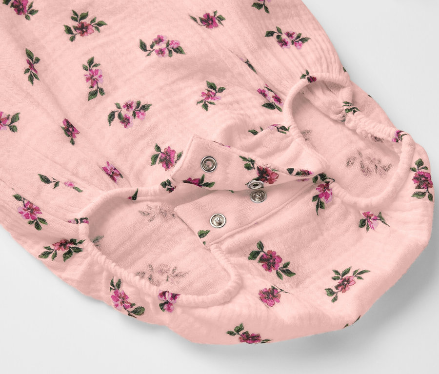 Detailansicht eines Baby-Musselin-Bodys mit Blumenmuster und Druckknopfverschluss.