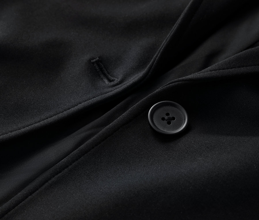 Detailaufnahme eines schwarzen Jerseyblazers mit Knopf.